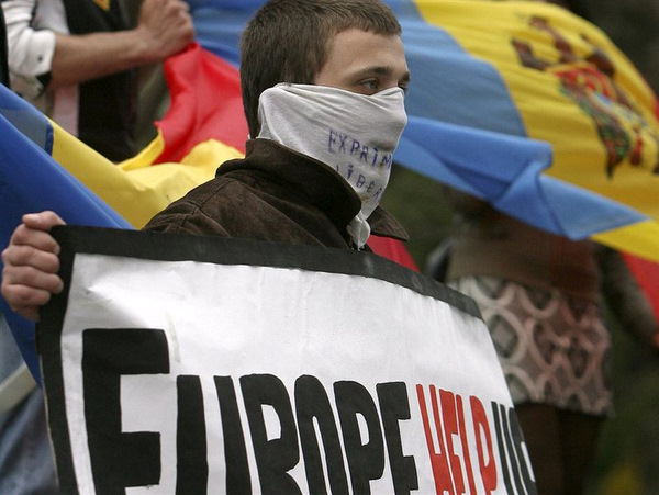 A Moldovan protester holds a sign reading 'Europe Help Us.' Events in Chisinau have shown unexpected instability just beyond the EU's borders.